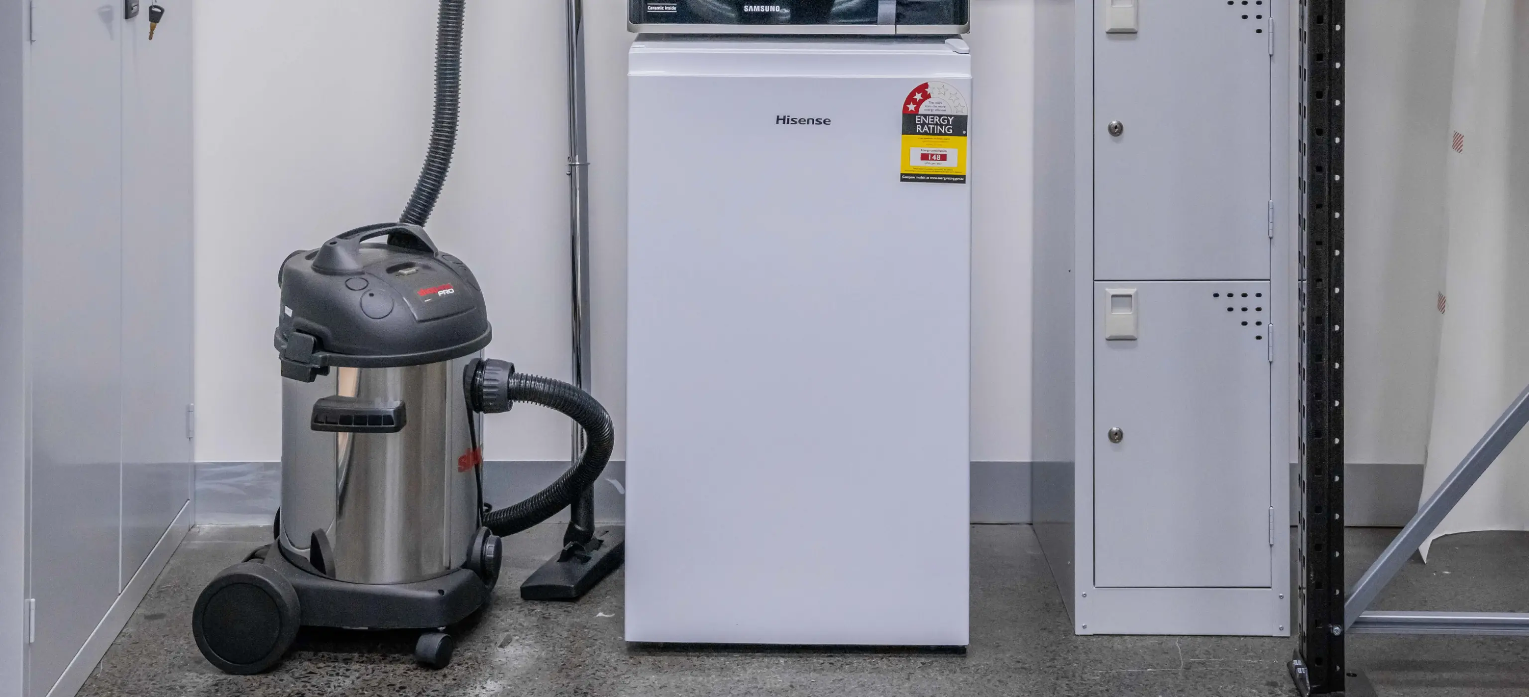 Backroom storage setup for cleaning equipment and appliances with organised utility shelving